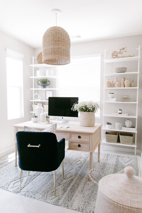 a neutral modern farmhouse home office with white storage units, a whitewashed desk, a black chair, a woven pendant lamp