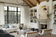 a neutral modern farmhouse living room with a fireplace, built-in shelves, a neutral sofa and chairs, a coffee table and a grey loveseat
