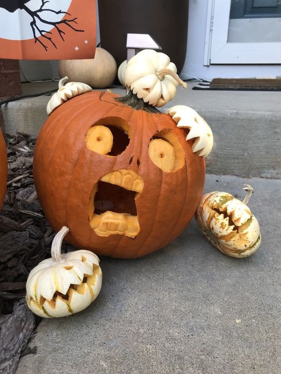 a scary pumpkin carved and being eaten by other, smaller pumpkins will create a spooky scene for Halloween
