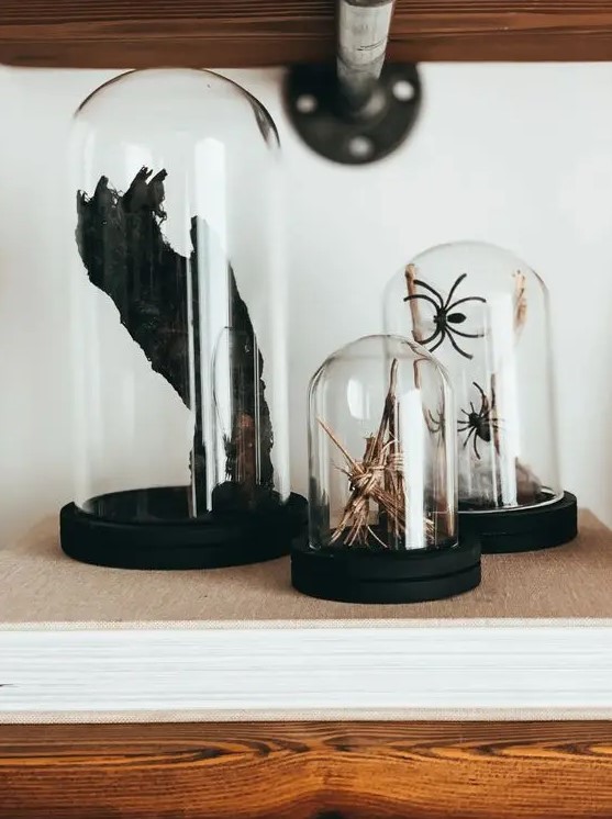 a series of cloches with spiders, brooms and a scary black paw will make your space feel like Halloween