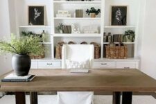a simple modern farmhouse home office with a large white built-in storage unit, a heavy desk, a white chair, a black chandelier