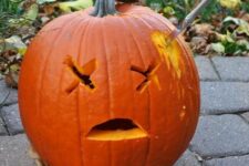 a very easy carved Halloween pumpkin with a knife in it is a creative and cool last-minute idea to realize