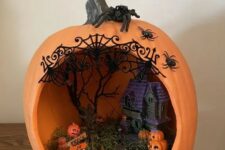 an orange pumpkin with a haunted house, hay and a scary tree plus a number of jack-o-lanterns is a great idea for Halloween