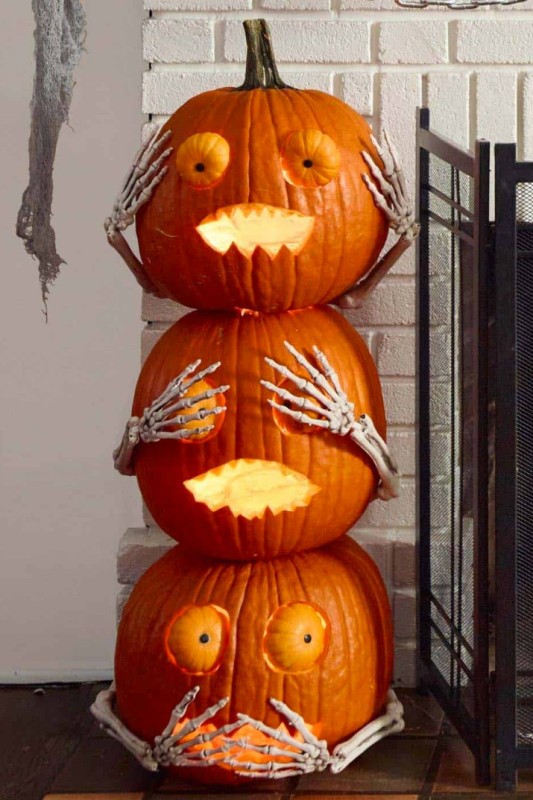 carved and stacked pumpkins with pumpkin eyes and skeleton hands will be nice Halloween decor for both indoors and outdoors