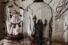 stylish Halloween cloches with a ghost and a banner, a haunted house with pumpkins and a blackbird on top