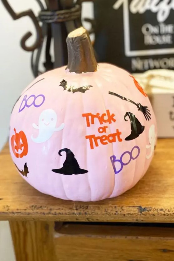 a pink pumpkin with ghosts, pumpkins, bats, witches' hats and brooms plus colorful letters is a cool solution