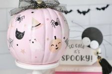 33 a cute light pink pumpkin with painted cats, ghosts, pumpkins, spiders and a black bow on top is amazing for Halloween