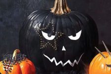 36 a stylish black and white Halloween pumpkin with a face and a star-shaped tattoo done with decorative pins