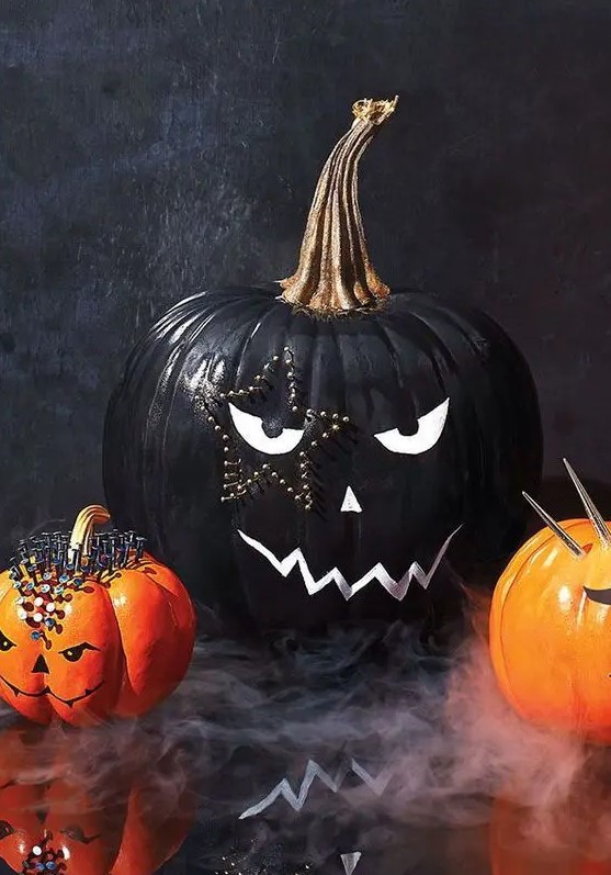 a stylish black and white Halloween pumpkin with a face and a star shaped tattoo done with decorative pins