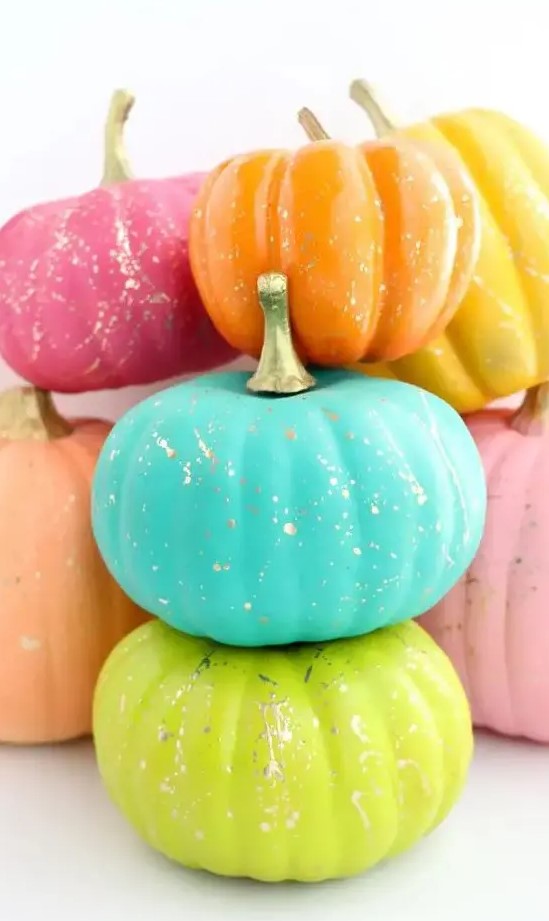 neon blue, green, orange, pink and yellow pumpkins with gold splatters are fantastic for Halloween decor