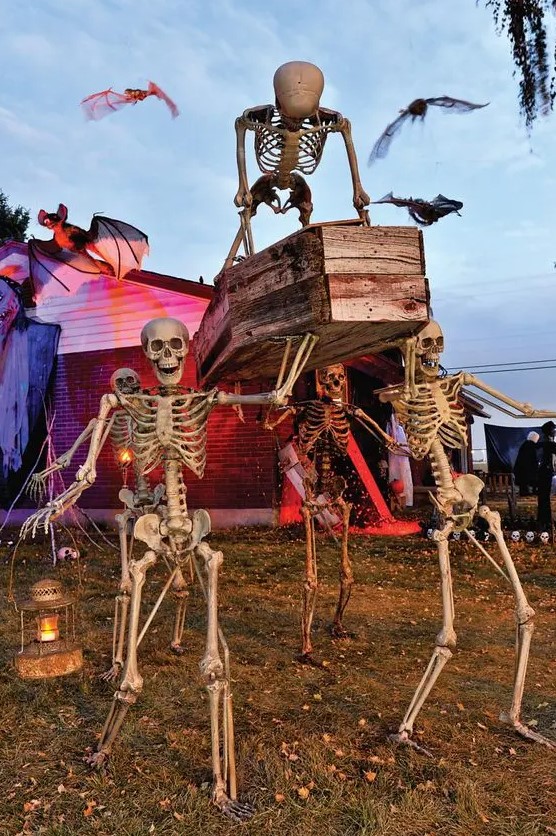 a Halloween skeleton scene with a coffin and lanterns is a cool idea for Halloween yard decor