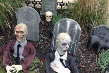 a Halloween yard decoration with tombstones and zombies, with a black cat and a skull is a cool idea