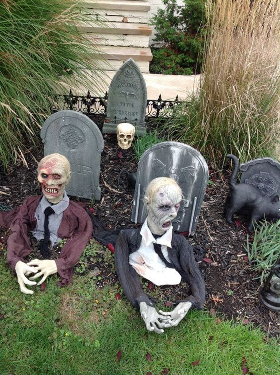 a Halloween yard decoration with tombstones and zombies, with a black cat and a skull is a cool idea