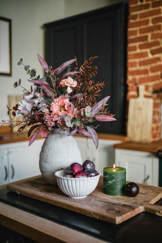 a beautiful and refined fall faux flower arrangement in pink, lilac and blush, with eucalyptus and bold leaves