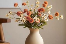 a beautiful fall faux flower arrangement in rust and white is a perfect decoration for lots of spaces