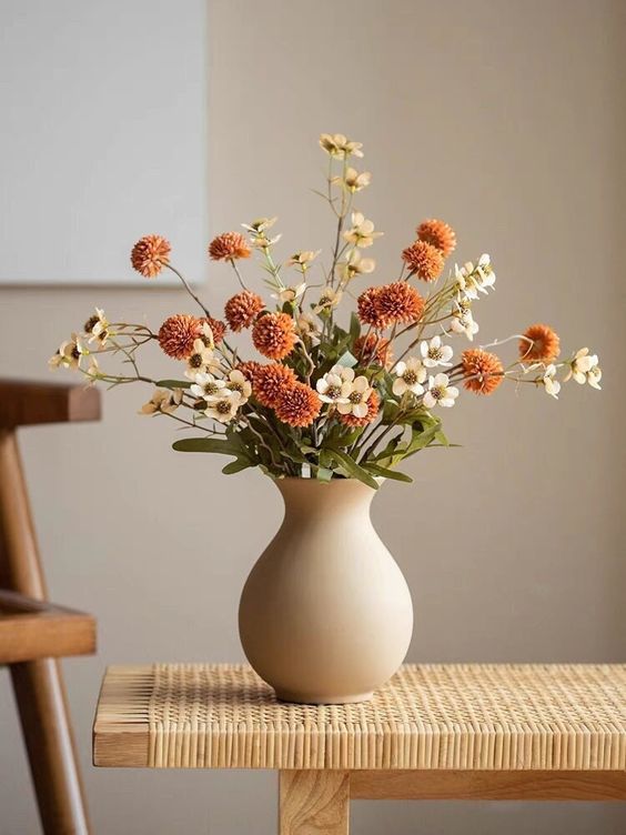 a beautiful fall faux flower arrangement in rust and white is a perfect decoration for lots of spaces