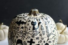 a beautifully decorated Halloween pumpkin with cats, bats, a graveyard, various Halloween stuff, all drawn with a sharpie