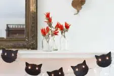 a black cat garland with lights is a stylish idea for Halloween, it looks cool and bold and isn’t difficult to make