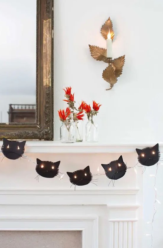 a black cat garland with lights is a stylish idea for Halloween, it looks cool and bold and isn't difficult to make