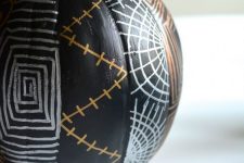 a black pumpkin with Halloween patterns in copper and silver is a cool idea to realize yourself