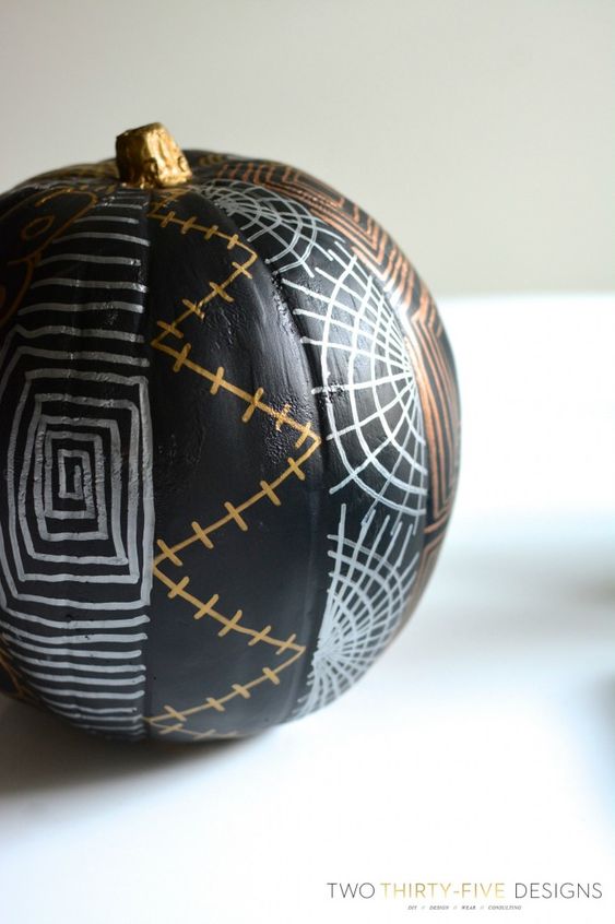 a black pumpkin with Halloween patterns in copper and silver is a cool idea to realize yourself