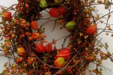 a branch and twig fall wreath with dried blooms, blooming branches and berries is a colorful fall piece