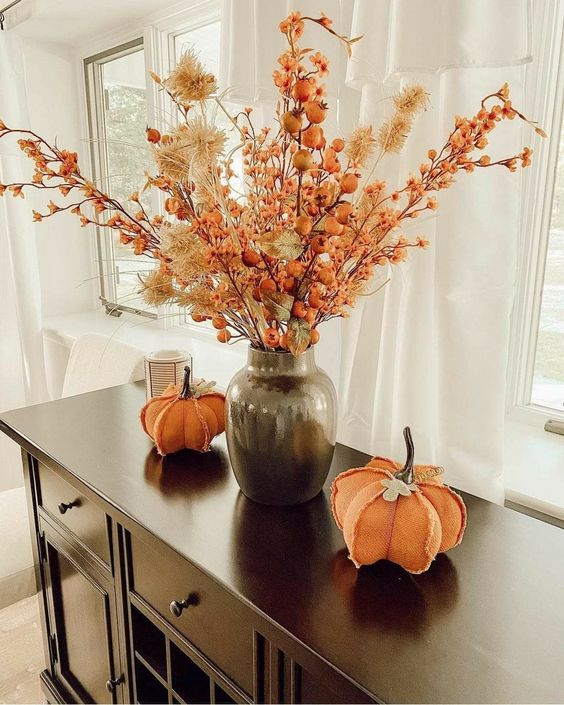 a bright dried flower arrangenment with berries and grasses done in orange and neutrals is a cool idea for the fall