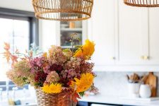 a bright faux flower arrangement in purple, burgundy, mellow yellow and blush, placed in a basket, is a cool way to add color