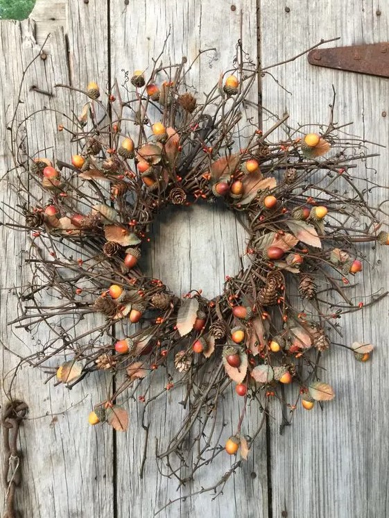 a bright natural fall wreath with twigs, acorns, berries, pinecones is lovely way to add a woodland feel to the space