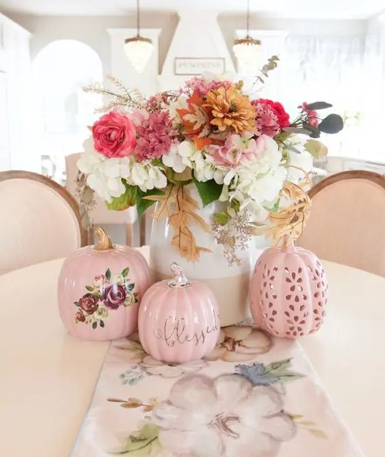 a chic and bright fall flower arrangement of white, pink, rust blooms and greenery and pink faux pumpkins