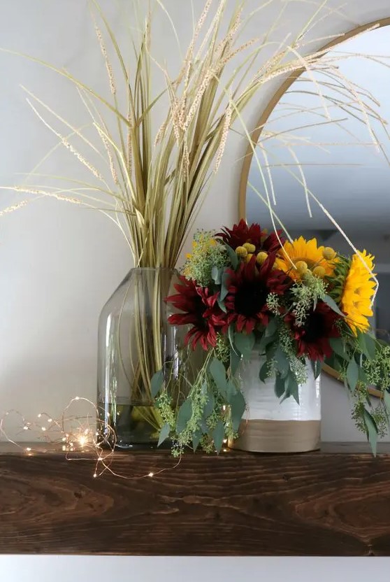 a chic fall faux flower arrnagement with lots of eucalyptus, burgundy and yellow blooms plus a grass arrangement