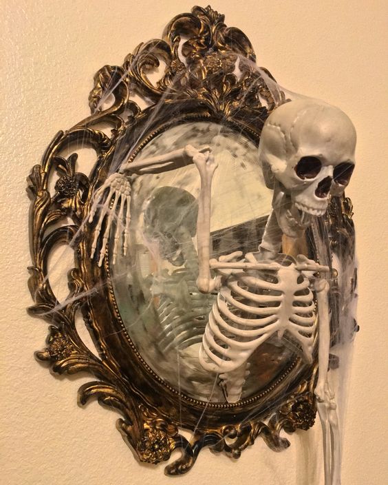 a chic mirror in a whimsical vintage frame, with spiderweb and a skeleton is a perfect decoration for Halloween