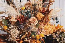 a colorful dried flower arrangement with billy balls, some grasses, dried blooms and grasses is amazing for fall or Halloween