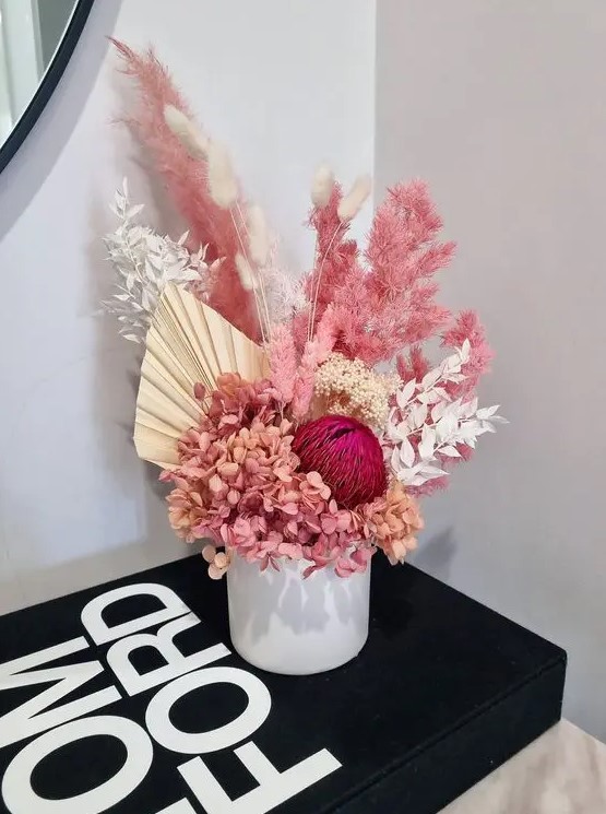 a colorful dried flower centerpiece with hydrangeas, fronds, leaves and pampas grass splus bunny tails will make a statement with its color
