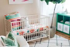 a colorful tropical-inspried small nursery with floral, palm prints, potted greenery and artworks