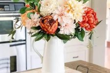 a cool floral Thanksgiving centerpiece of blush, peachy and orange blooms plus greenery is a simple and lovely idea