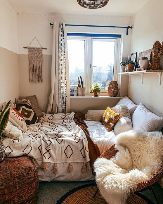 a cozy boho bedroom with a bed, a shelf with decor, a chair with faux fur and a pouf plus a lot of boho decor