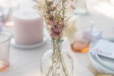 a delicate dried flower centerpiece of a bottle with dried pink blooms and some grass is a chic solution for fall