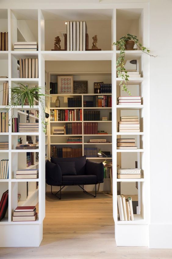 a doorway finished off with built in bookshelves that double as space dividers and provide a lot of book storage space