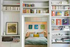 a doorway surrounded with open shelves used for storing books and artworks is a very cool idea to go for