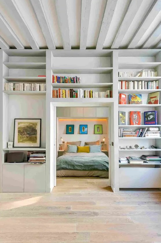 a doorway surrounded with open shelves used for storing books and artworks is a very cool idea to go for