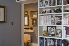 a doorway wall covered with open shelves that contain lots of books is a cool idea to organize your home library without wasting a lot of space