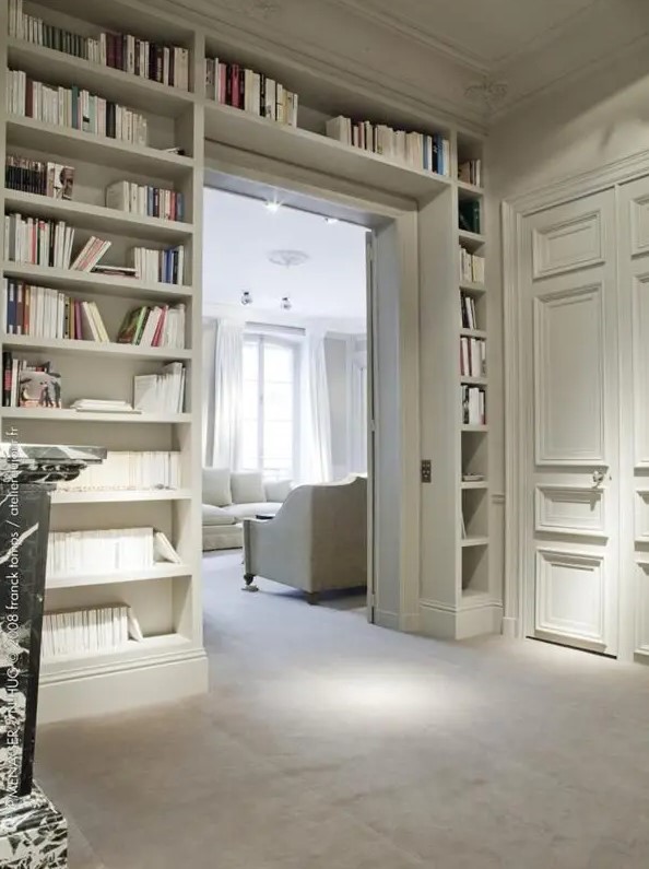 A doorway with built in open shelves on both sides and over the door is a smart idea to store books and not to place a boring bookshelf somewhere