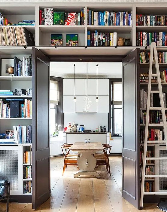 a doorway with open shelves over the door and around it is like organizing a whole library around the door without wasting floor space