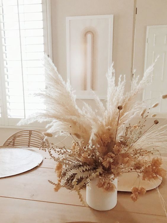 a dried flower and grass arrangement with various types of them looks cool and will make your fall decor more stylish