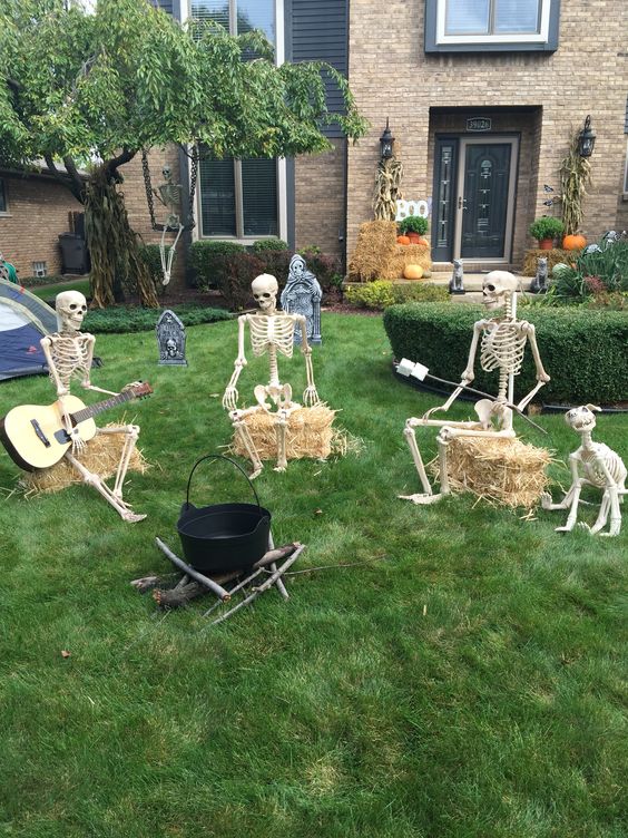 a funny skeleton Halloween scene with a cauldron, skeletons singing songs, a dog and tombstones is amazing