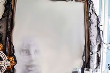 a ghost mirror covered with black cheesecloth can be made by you yourself, it’s a great decor idea for Halloween