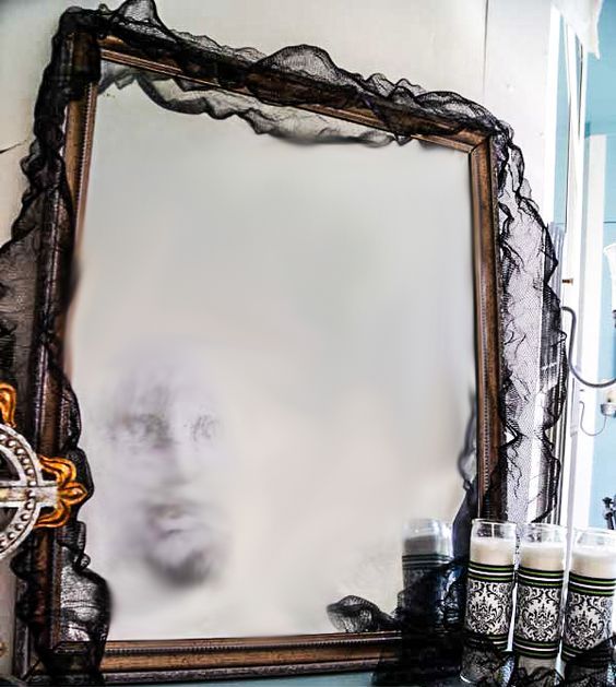 a ghost mirror covered with black cheesecloth can be made by you yourself, it's a great decor idea for Halloween
