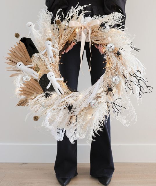 a gorgeous neutral Halloween wreath with mummies, spiders, disco balls, twigs annd fronds is a super cool idea