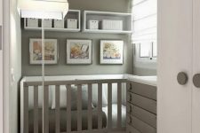 a grey and white small nursery with a built-in crib and a grey dresser that doubles as a changing table and shelves with baskets for storage